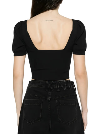 Black crop top with open back worn by a person on a white background