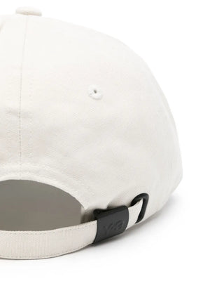 White cap with a black strap and logo by Y-3