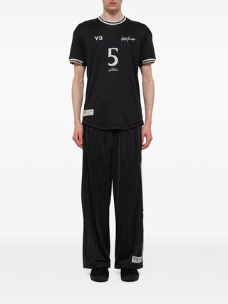 Person wearing a black sports outfit with visible branding by Y-3