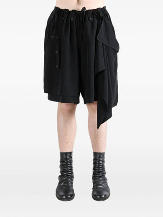 Person wearing black shorts with black boots by Yohi Yamamoto