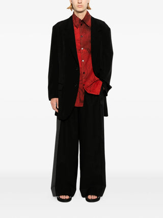 Person wearing a black suit with a red shirt 